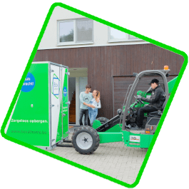 A young couple watch happily as the Box@Home driver positions their Large Box in front of their door.