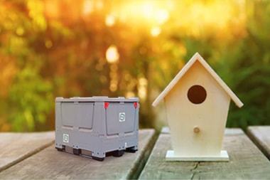 Een miniatuurversie van de Small Box staat naast een vogelhuisje