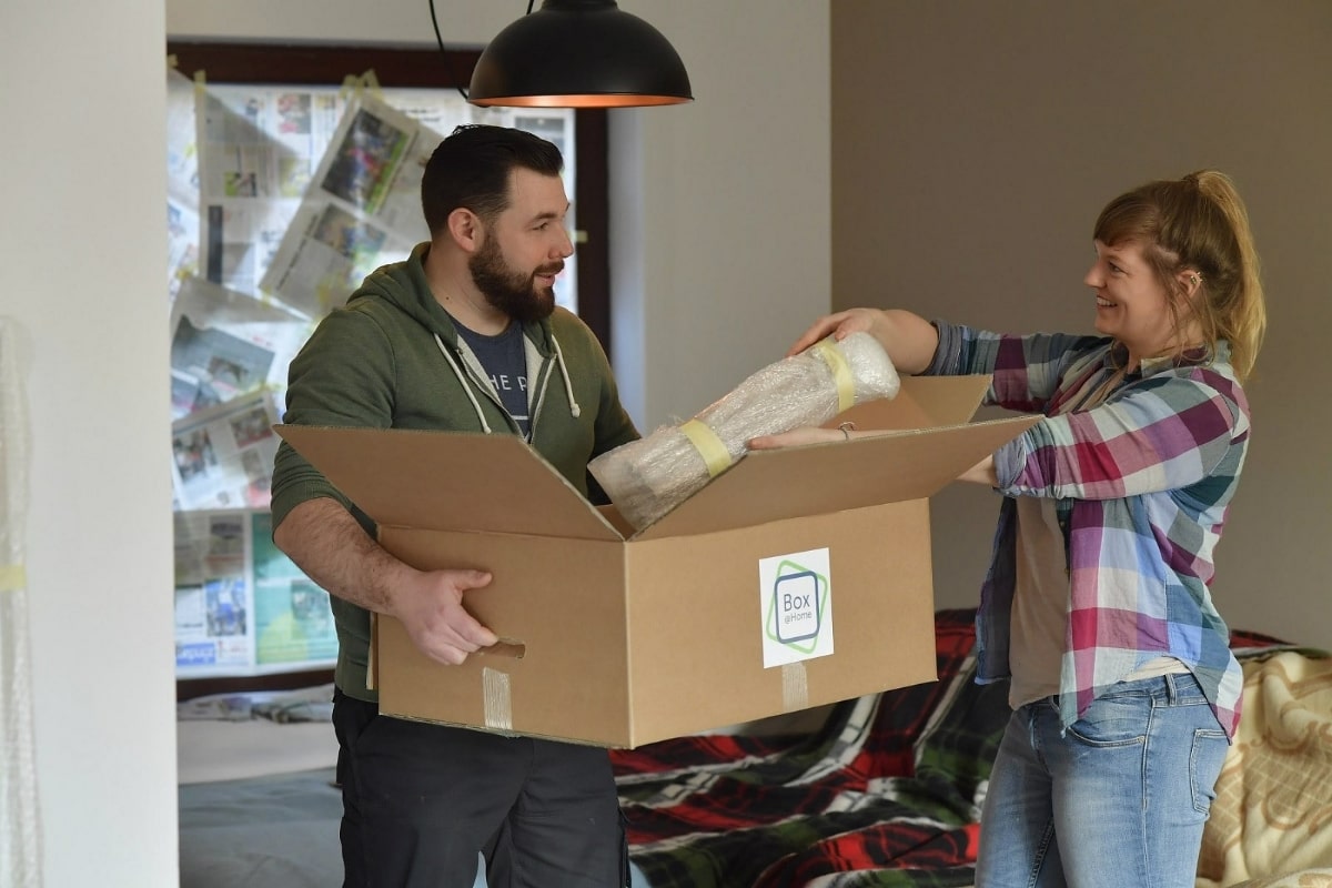 Un couple qui va rénover son salon dépose ses affaires dans les boîtes de déménagement de Box@Home.